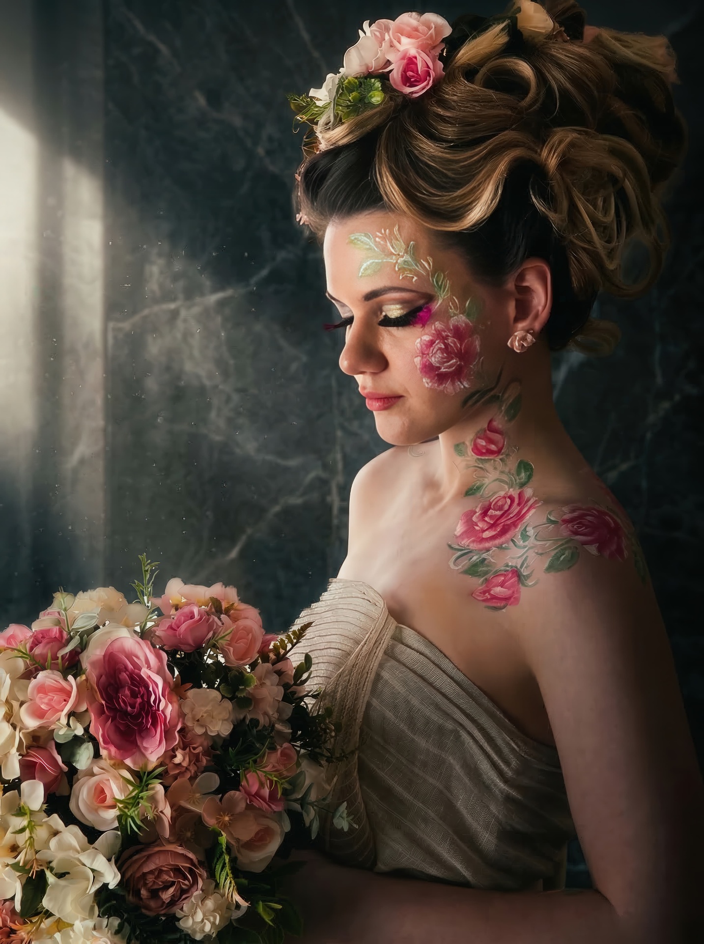 Woman with a floral updo looking down, holding a bouquet, with painted roses on her face and shoulder