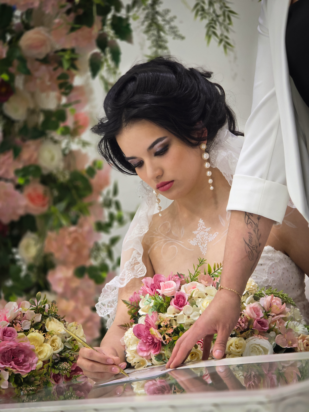 Bride signing a document at the ceremony, holding a bouquet