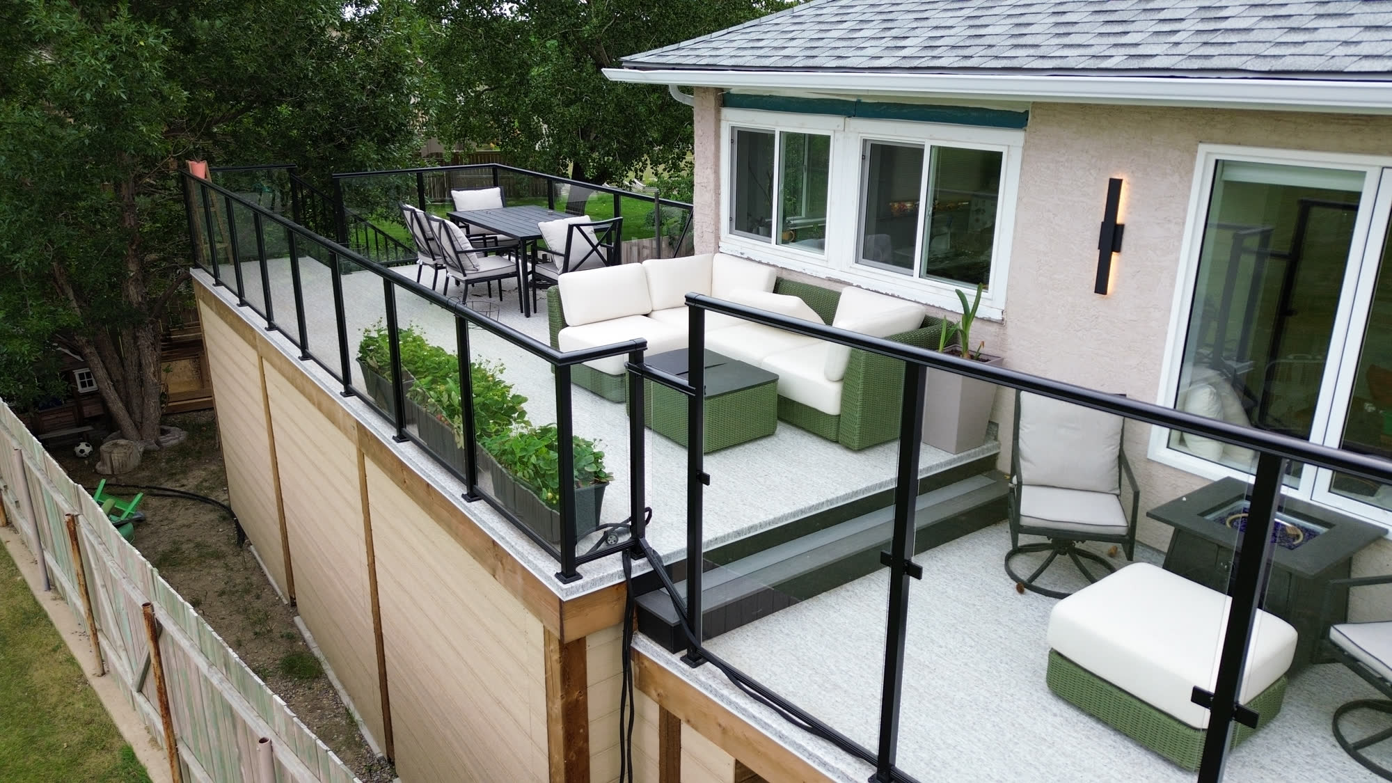 Aerial close-up of a raised deck with lounge seating, dining set and planter boxes